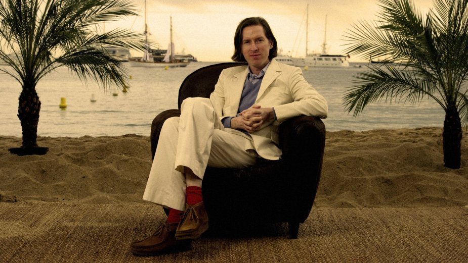 Director Wes Anderson sits in chair on beach